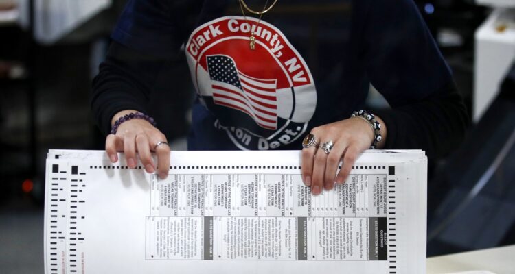 Una funcionaria electoral con las papeletas de las elecciones.