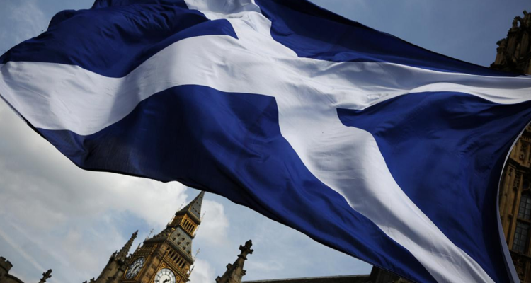 Una bandera escocesa flameando frente al Parlamento británico.