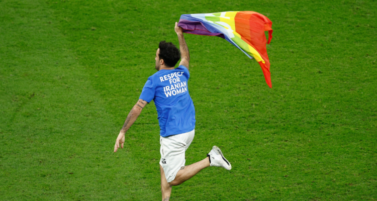 hincha ingresa con la bandera LGBTI+ a la cancha del estadio Lusail en el duelo entre Portugal y Uruguay.