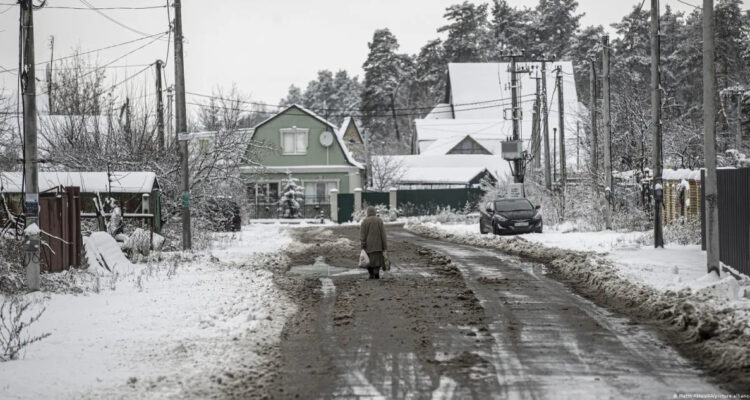 Un ciudadano camina entre la nieve en la aldea de Moschun, que ha sido destruida como resultado del intenso bombardeo del ejército ruso, ahora las condiciones de vida se vuelven más difíciles con las primeras nevadas.