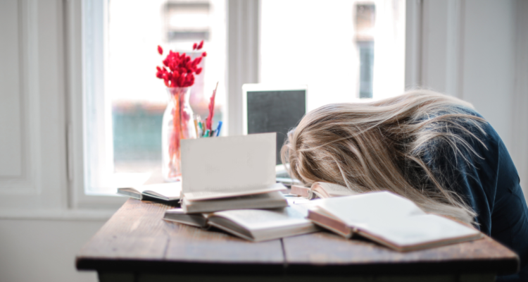 Mujer dormida sobre su escritorio de trabajo. Estudio sugiere que cansancio en dias laborales se debe a Jet Lag Social