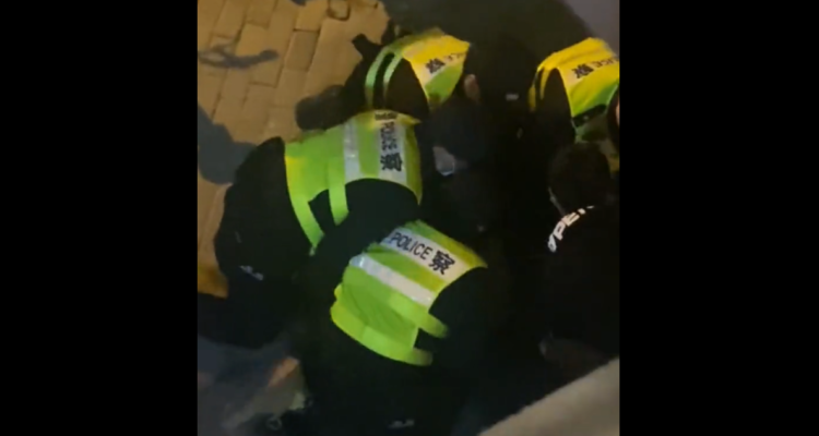 Policías chinos arrestando a Lawrence, periodista de la BBC.