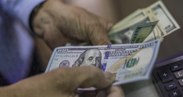 Operador cuenta dólares en casa de cambio.