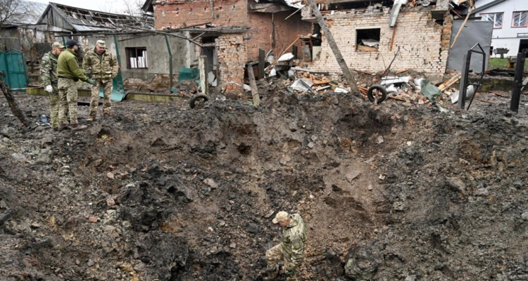 Unos expertos de la policía examinan un cráter tras un ataque con misiles en una localidad cercana a la ciudad ucraniana.