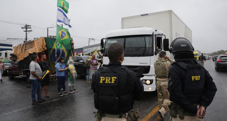 Miembros de la policía custodian a grupos de camioneros que bloquean carreteras en Río de Janeiro.