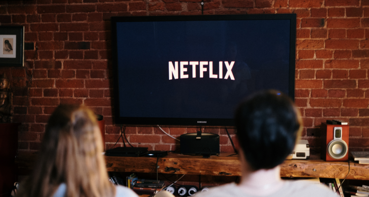 Personas mirando contenido de la plataforma de streaming Netflix. La plataforma no logró cantidad de usuarios que vieran anuncios
