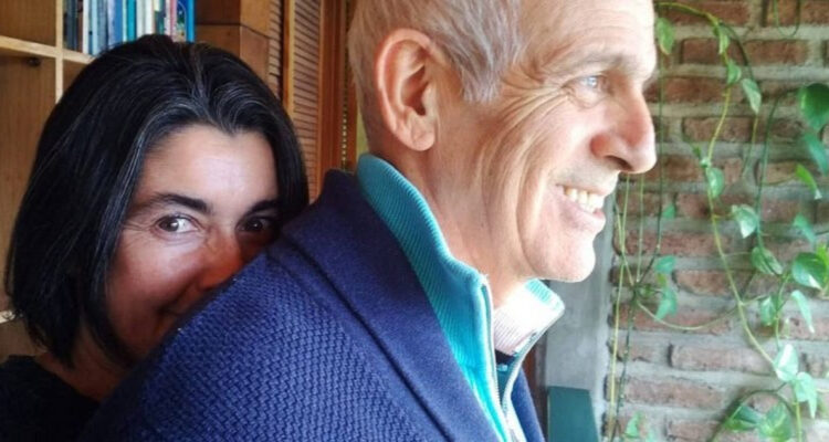La actriz Paulina Urrutia abraza a Augusto Góngora mientras sonríe levemente.