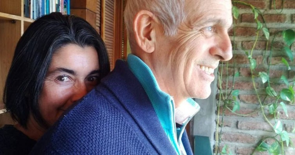 La actriz Paulina Urrutia abraza a Augusto Góngora mientras sonríe levemente.