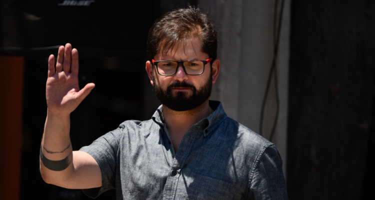 Imagen de Gabriel Boric, presidente de Chile, levantando la mano derecha (saludando).