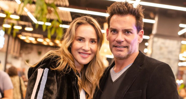 La animadora Angélica Castro posa junto al actor Cristián de la Fuente sonriendo.