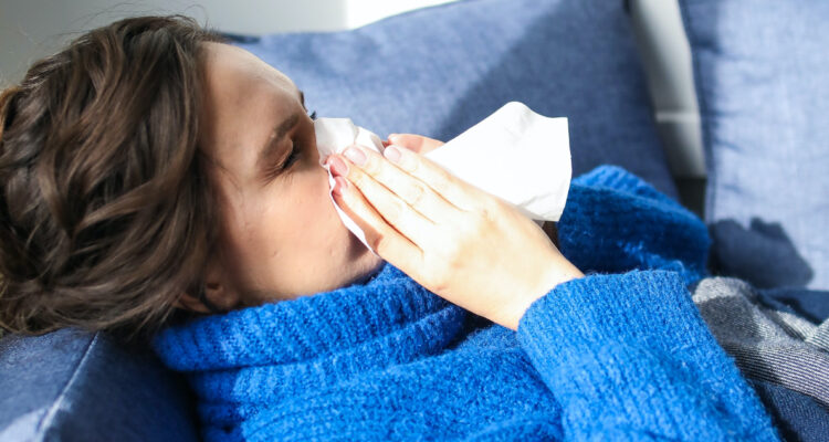 Una mujer utiliza un pañuelo mientras se ve enferma.
