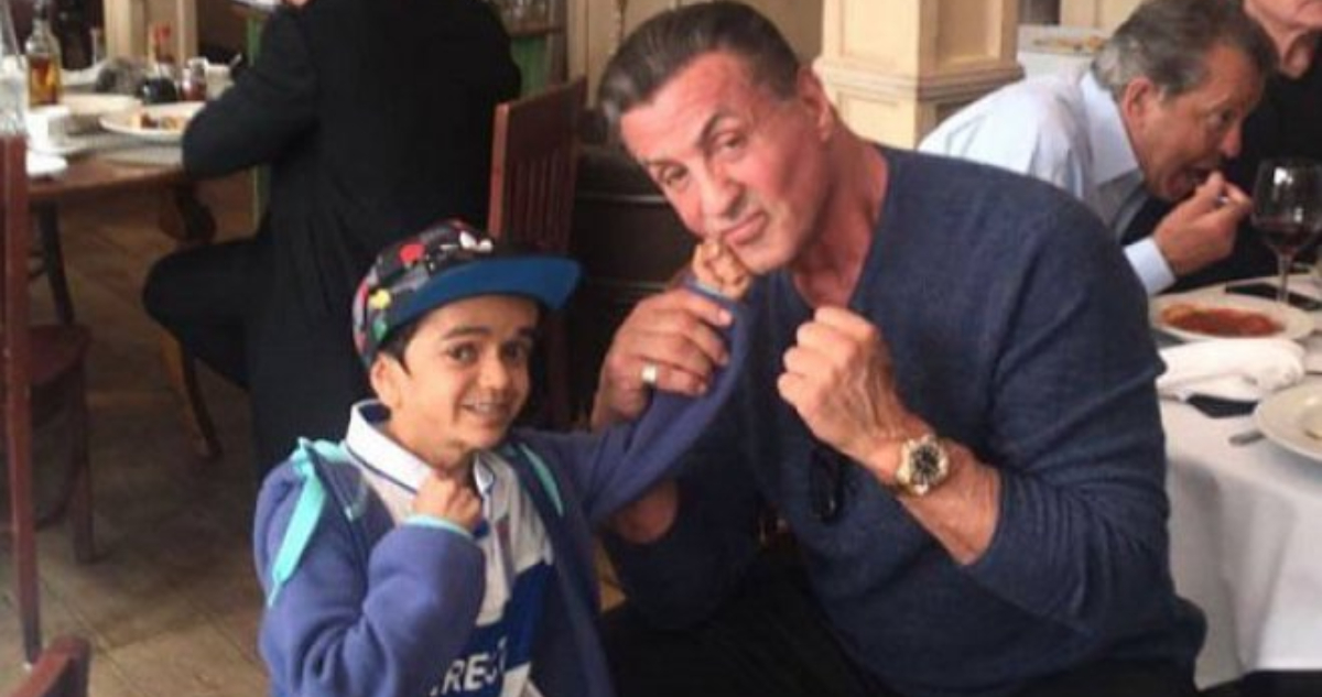 Miguelito posando con el actor Sylvester Stallone, quien hace posar a Miguelito como si le estuviera golpeando el rostro.