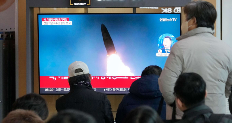 Personas observan en TV imágenes de los lanzamientos de misiles de Corea del Norte.