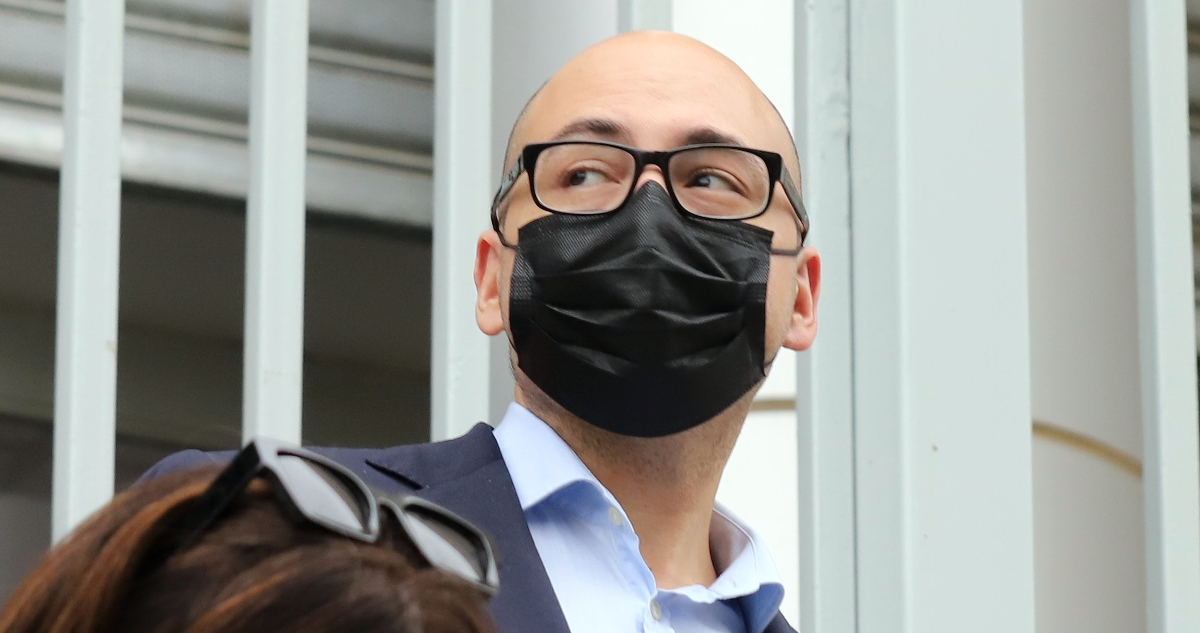 El cineasta Nicolás López mira hacia un costado mientras lleva mascarilla durante su juicio por abuso sexual.