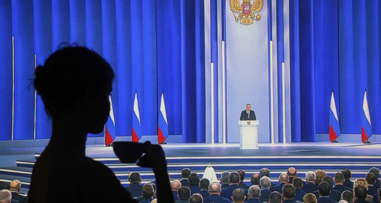 Una mujer ve desde su casa el discurso del presidente ruso, Vladímir Putin.