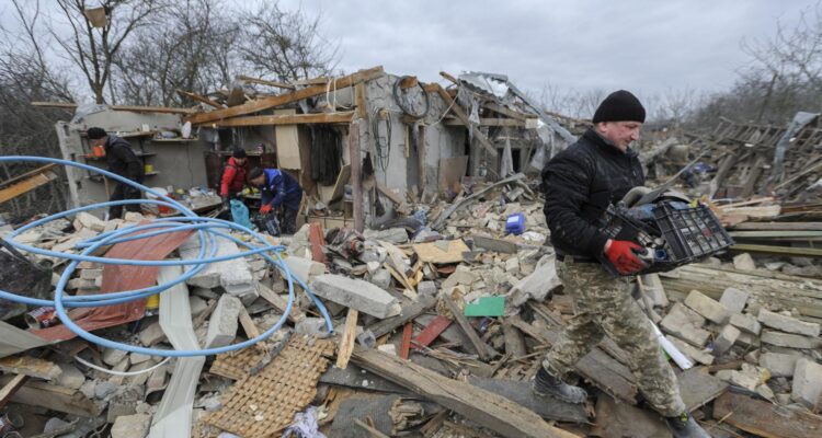Personas rescatan cosas luego que dos misiles impactaran en un área residencial en el distrito de Zolochiv, Ucrania
