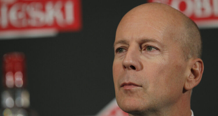 El actor Bruce Willis mira serio hacia su derecha en un evento.