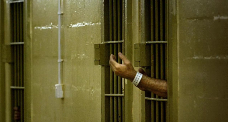 Un detenido iraquí gesticula hacia los soldados estadounidenses en la prisión de Abu Ghraib