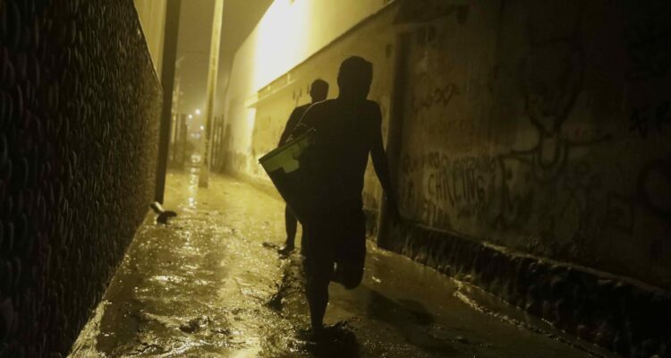 Pobladores de Punta Hermosa al sur de Lima, caminan en el lodo
