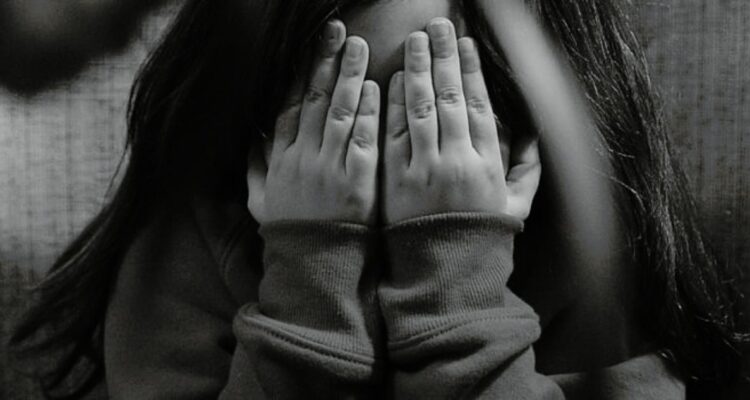 Niña cubre sus rostro en recreación de situación de vulneración de derechos.