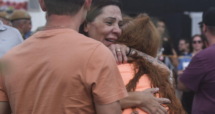 Familiares se abrazan a la entrada de la guardería Cantinho Bom Pastor