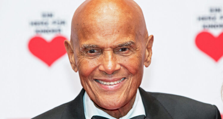 Harry Belafonte sonríe para las cámaras durante un evento de caridad.