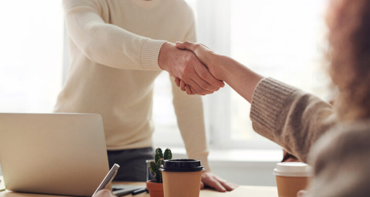 Hombre dando mano a mujer entrevista de trabajo
