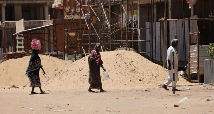Sudaneses caminan con botellas vacías y bidones mientras buscan agua potable