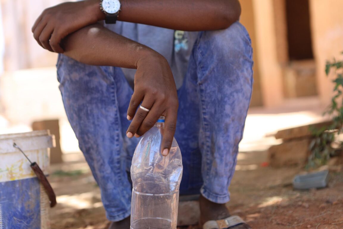 sudanés con una botella vacía