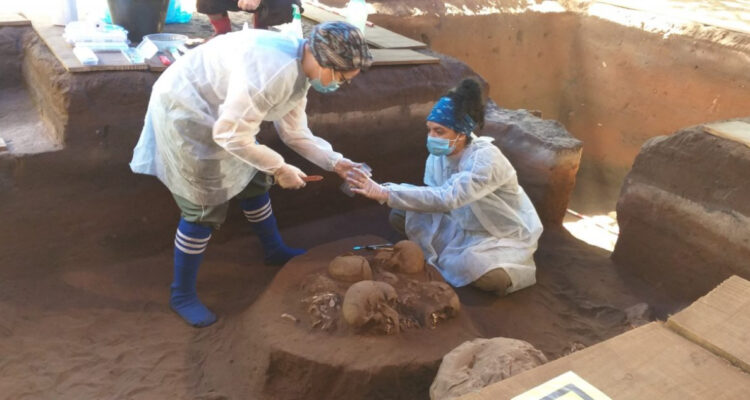 Dos arqueólogas con los cráneos que estaban a dos metros de distancia del equeleto de 12 mil años