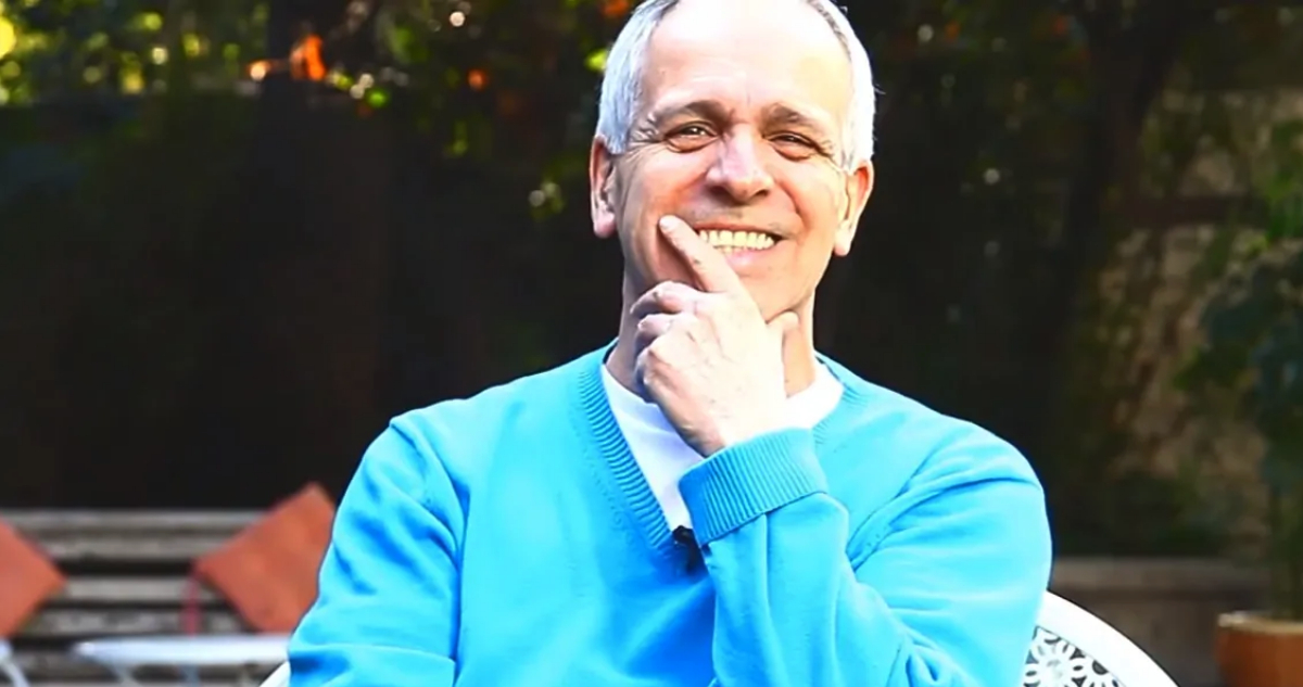 Augusto Góngora sonríe mientras se toma el rostro.