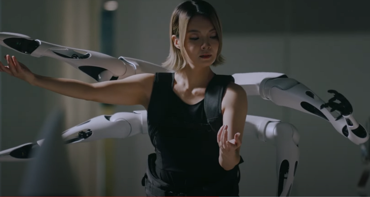Una captura del video en que una modelo baila con los brazos robóticos.
