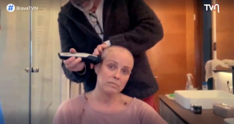 Claudia Conserva se mira en el espejo mientras rapa su cabeza.