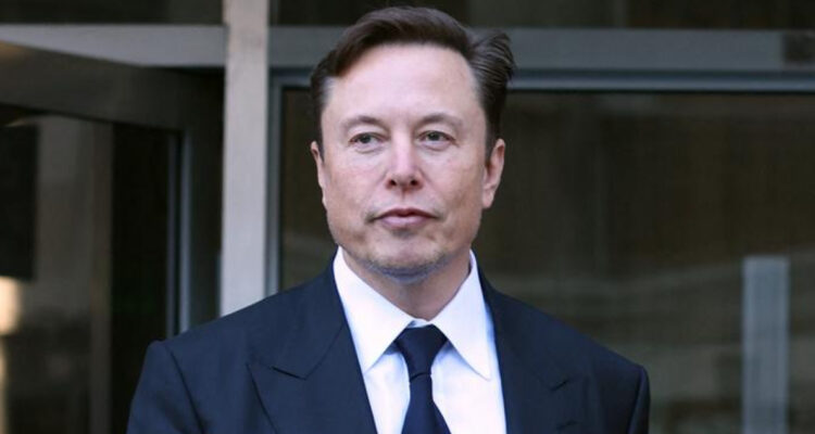 Elon Musk mira serio hacia un costado mientras camina.