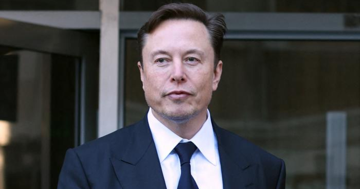 Elon Musk mira serio hacia un costado mientras camina.