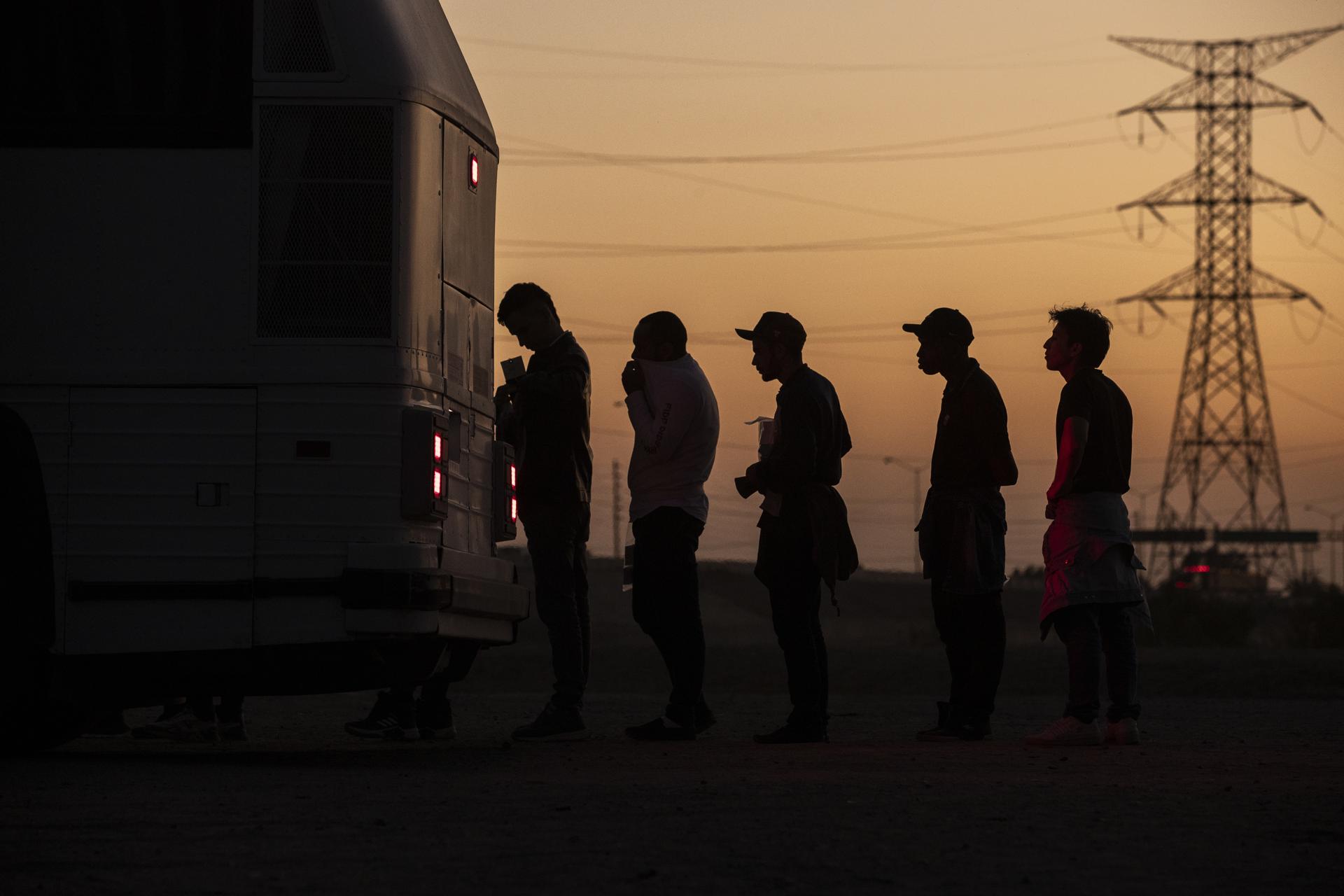 Migrantes llevados a un centro de procesamiento tras cruzar de México a EEUU