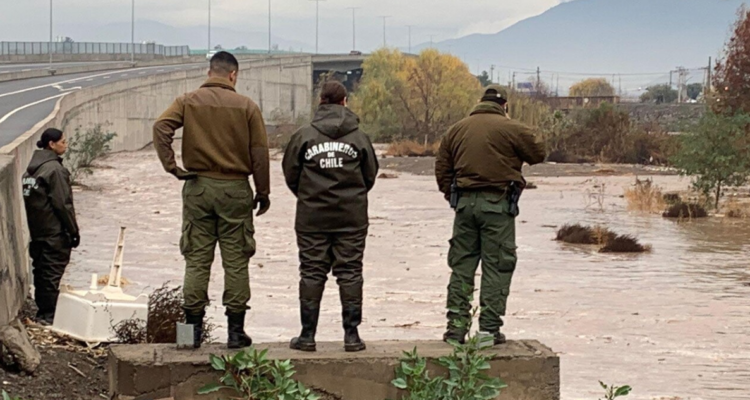 Carabineros a un costado de río.