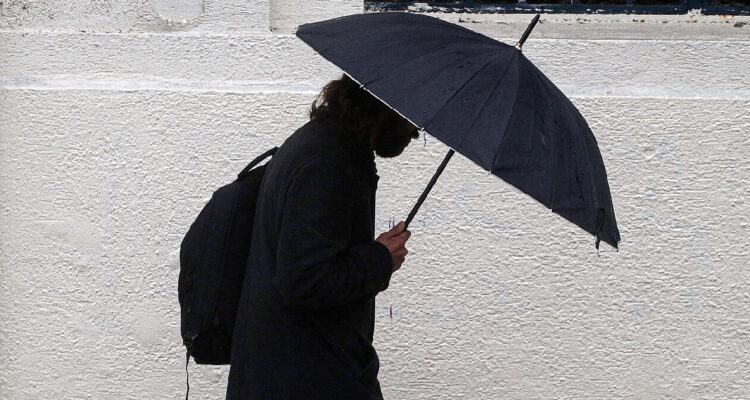 Persona con paraguas en medio del sistema frontal que azota el país