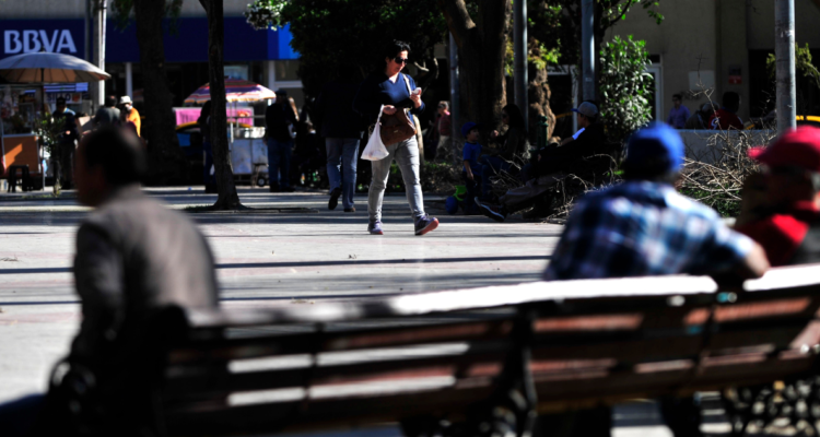 Una mujer camina por la Plaza de Armas de la ciudad de Copiapo
