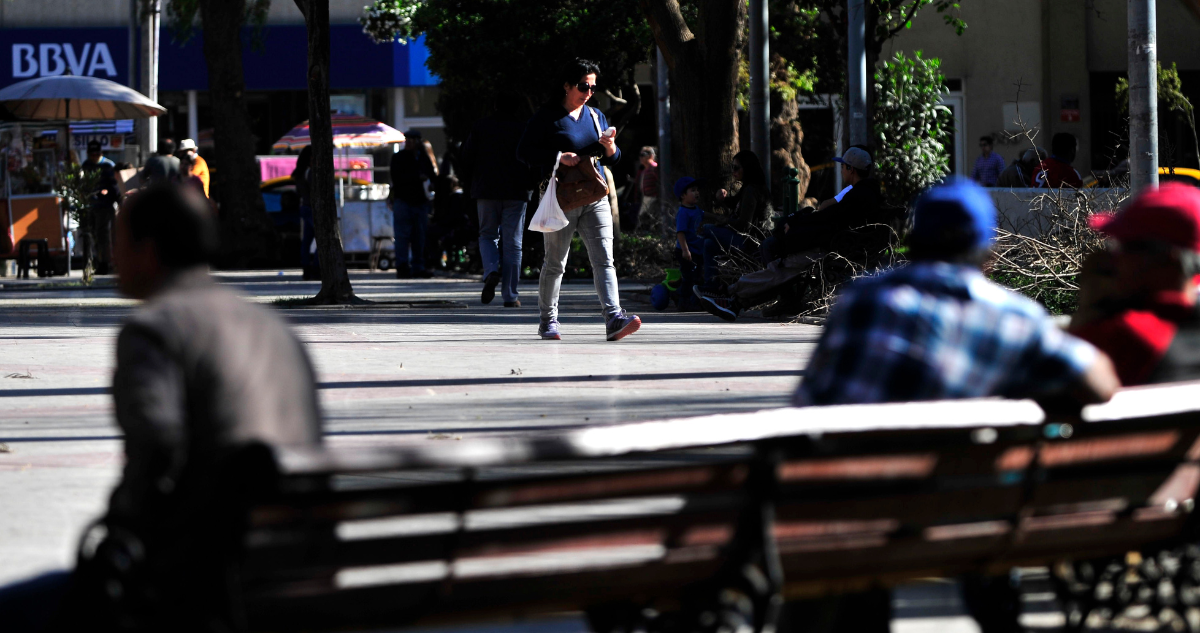 Una mujer camina por la Plaza de Armas de la ciudad de Copiapo