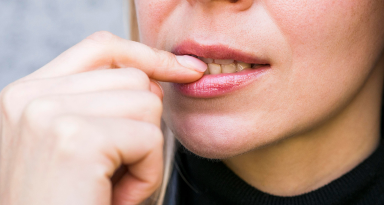 Mujer mordiéndose las uñas en referencia a estudio que encontró nueva forma de no hacerlo