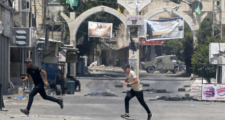 Ciudadanos palestinos corriendo en medio de los enfrentamientos.