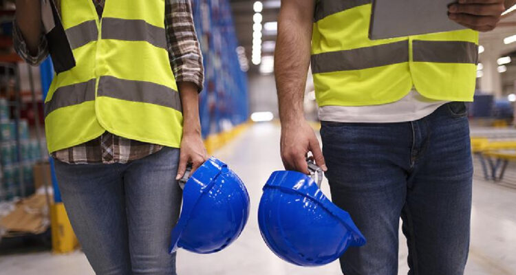 Dos trabajadores con sus casos azules en sus manos