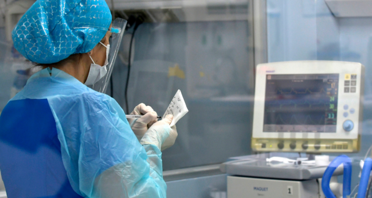 Enfermera monitoreando a paciente en un recinto médico.