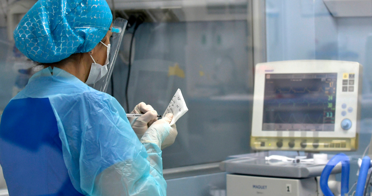 Enfermera monitoreando a paciente en un recinto médico.