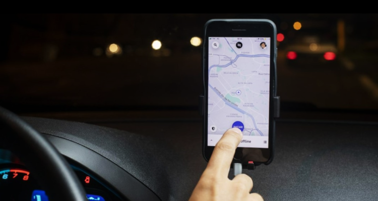 Conductor de Uber abre la aplicación en su teléfono.