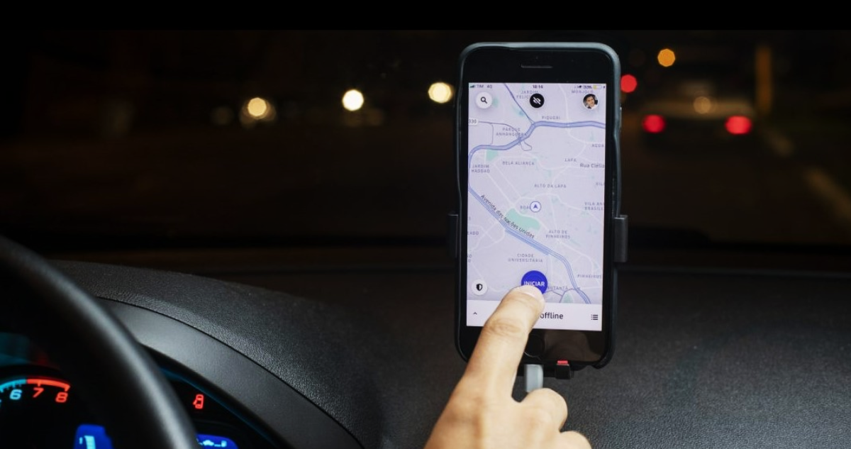 Conductor de Uber abre la aplicación en su teléfono.