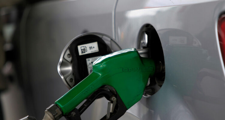 Surtidor de combustible echando bencina a un auto