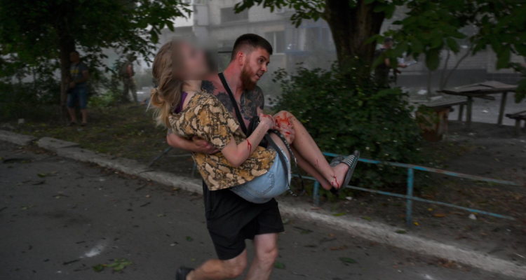 Hombre carga a una mujer herida tras el segundo impacto