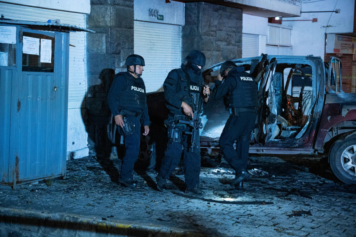 Policías investigan los restos de un carro bomba que explotó en  Quito